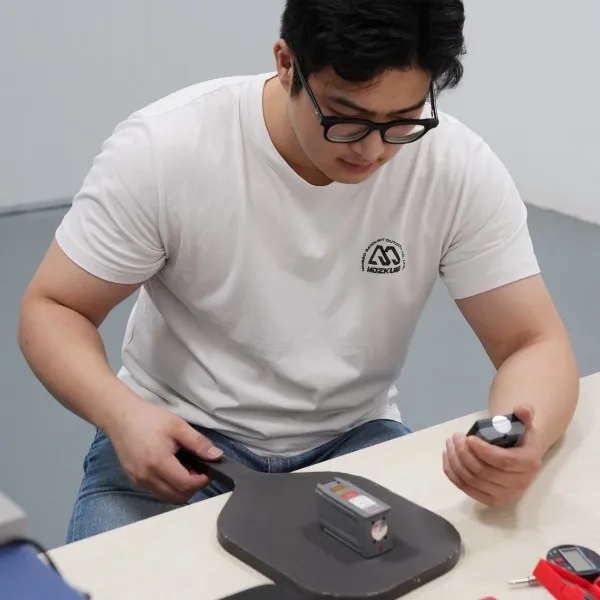 Mozkuib team testing a semi-finished pickleball paddle during production