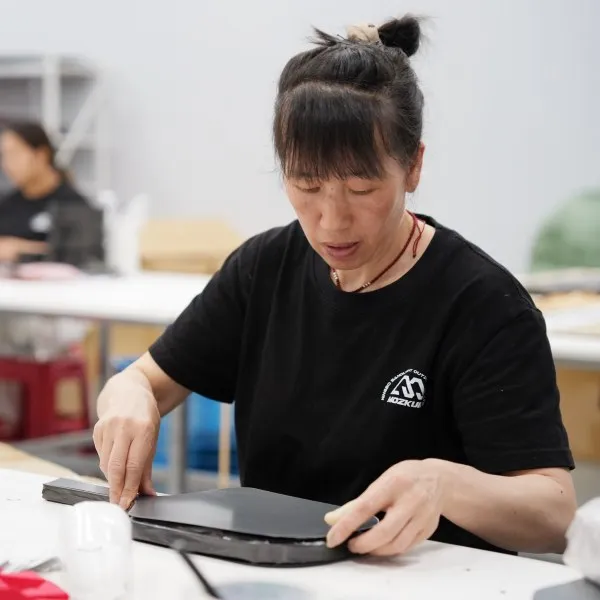 Mozkuib worker checking pickleball paddle structure and surface during production