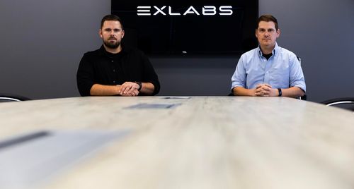 A grey architecture modern building with contemporary design style in a white sky blue sunrise background.