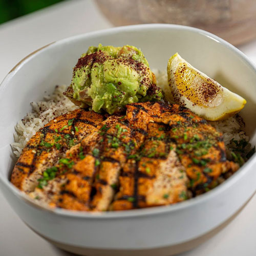Burrata cheese in tomato sauce garnished with basil leaves, served with toasted bread slices.