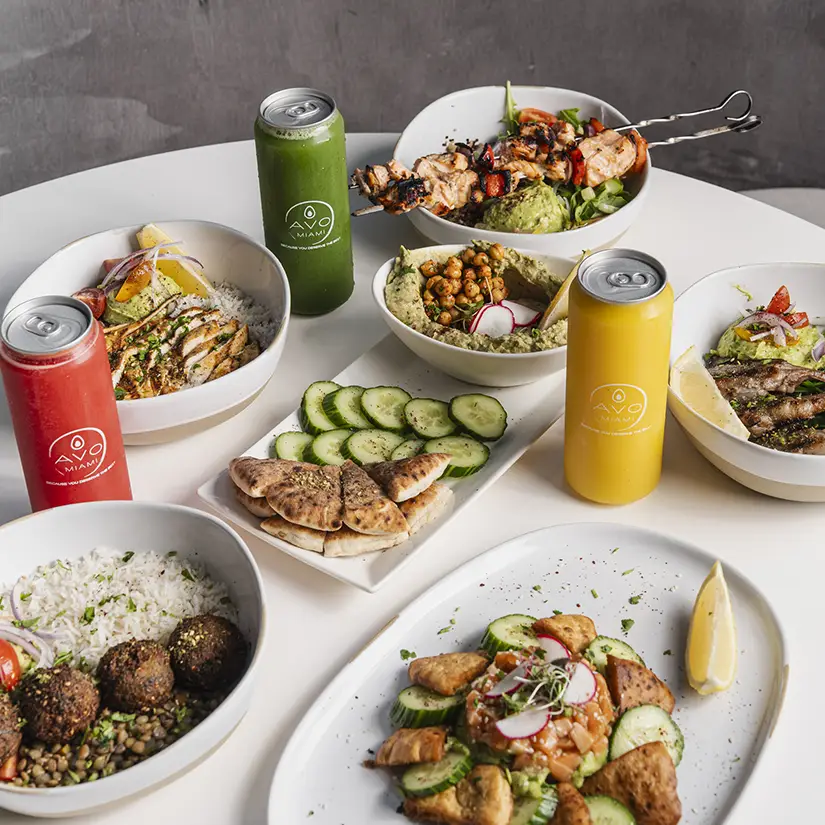 Four people enjoying a meal together at a restaurant table with drinks and plates of food.