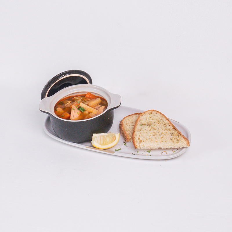 Burrata cheese in tomato sauce garnished with basil leaves, served with toasted bread slices.