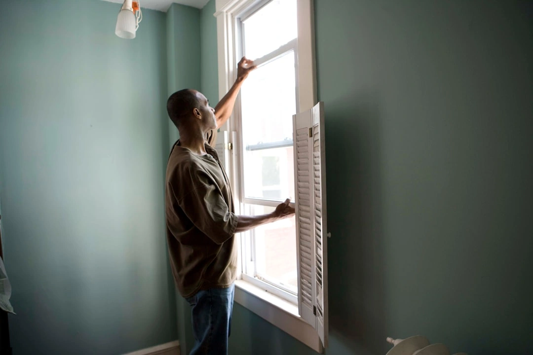 Homeowner checking a pleated air filter in a hallway intake vent Homeowner checking a pleated air filter in a hallway intake vent