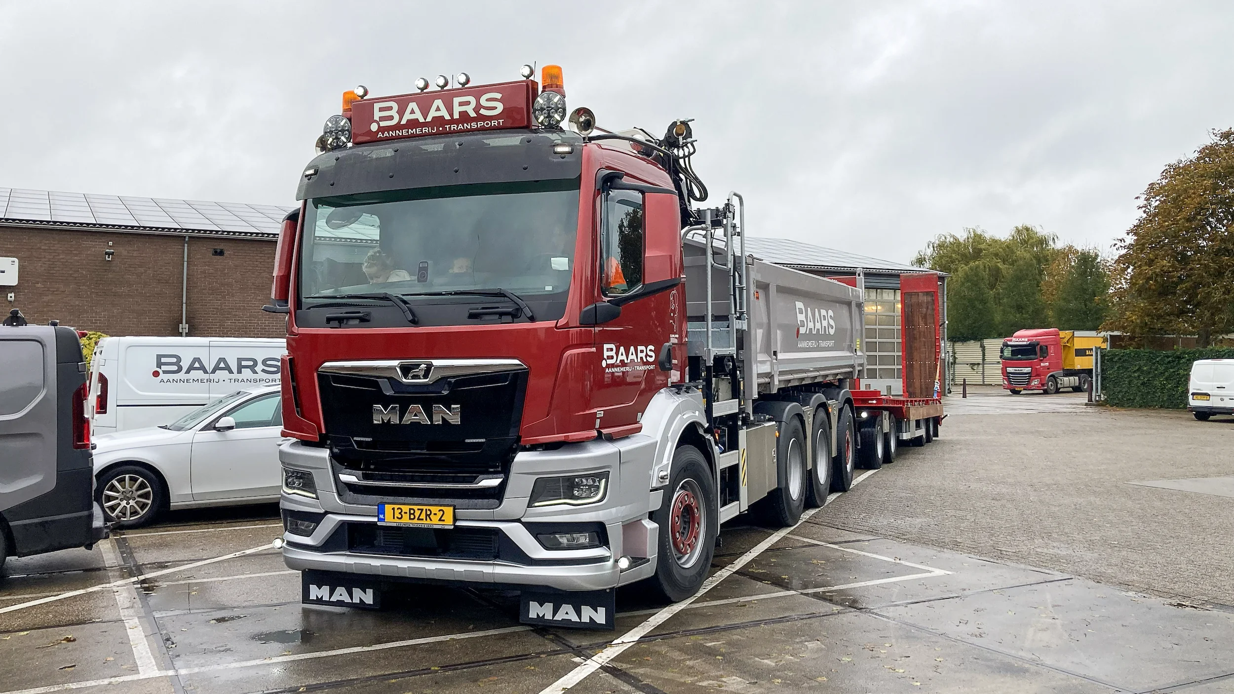 De nieuwe MAN vrachtwagen van Baars met gesloten kipper en opgeknapte Nooteboom dieplader, klaar voor transport.