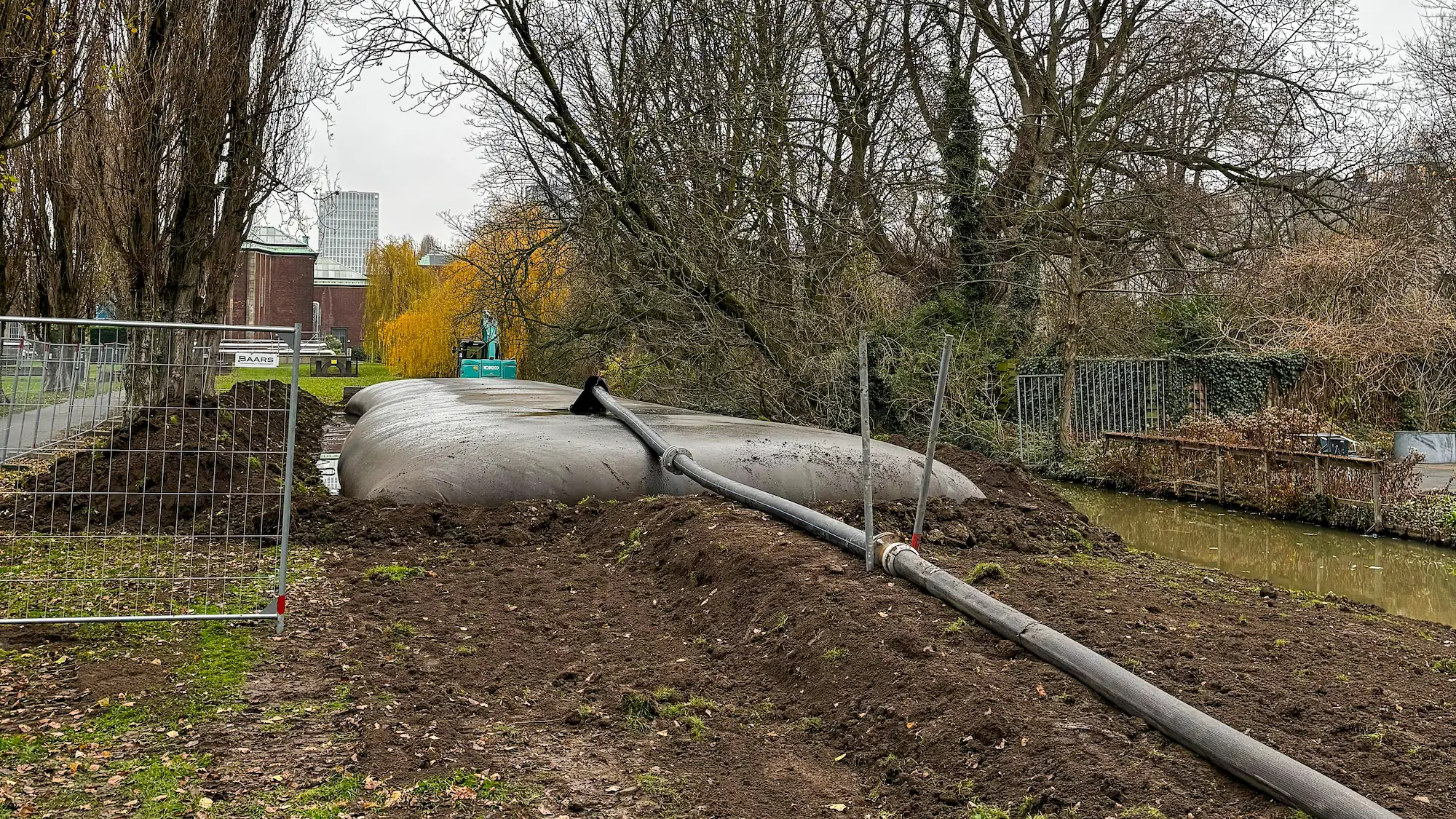 Biologisch afbreekbare baggertube langs de waterkant waarin de bagger wordt opgevangen en gedroogd voor hergebruik in het park.