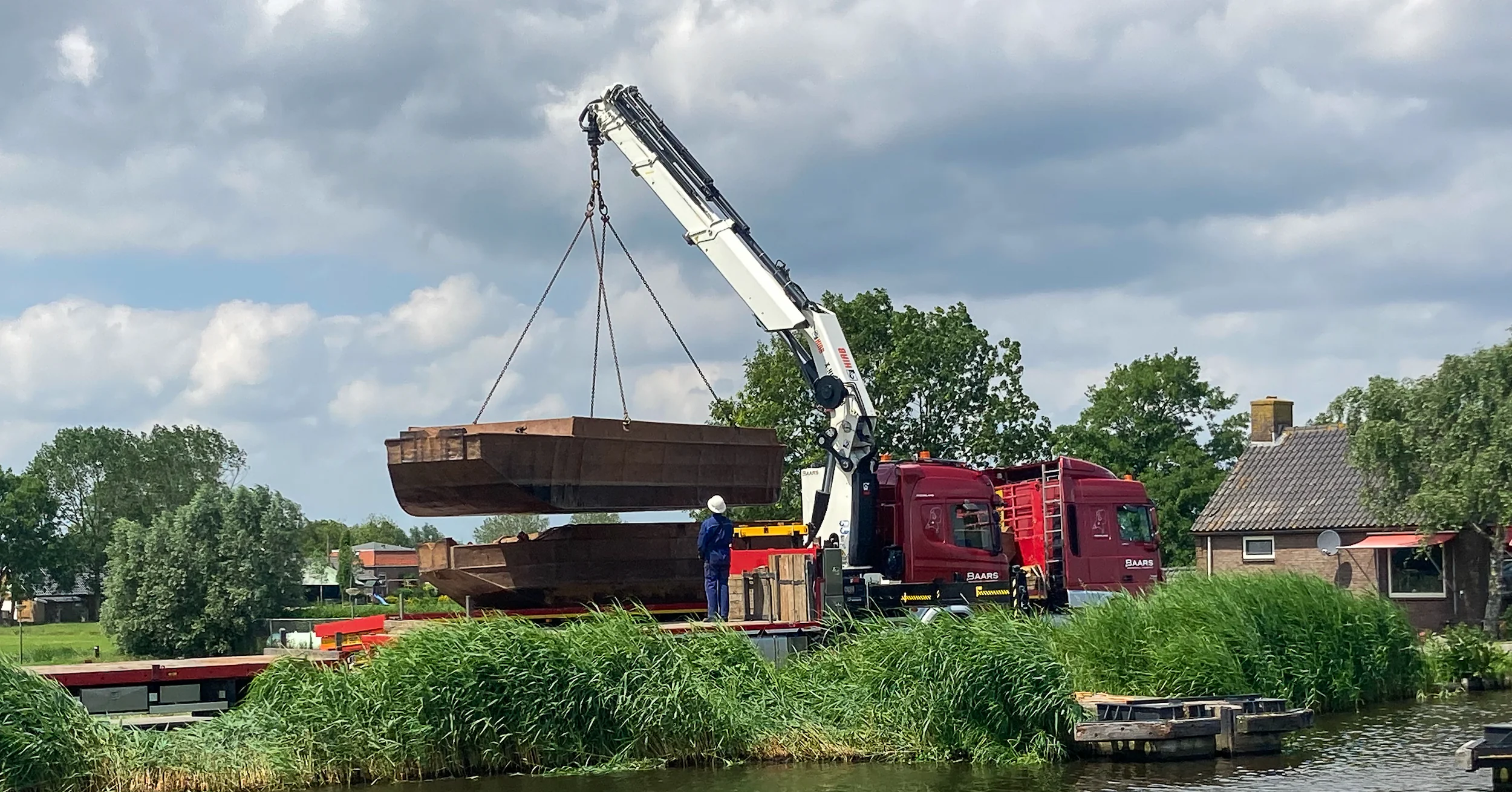 Pontondelen worden gelost vanaf de vrachtwagen op locatie aan het water