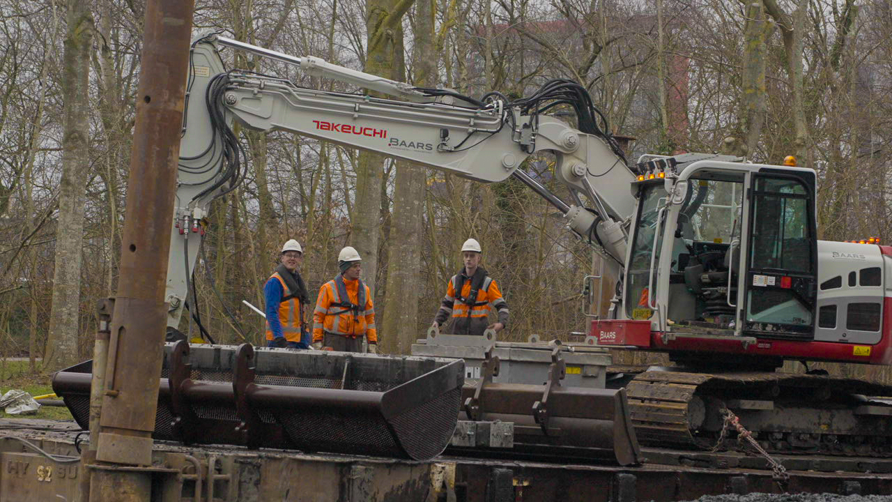 Team van Baars bespreekt werkzaamheden bij graafmachine op ponton tijdens project bij het Kruithuis in Delft