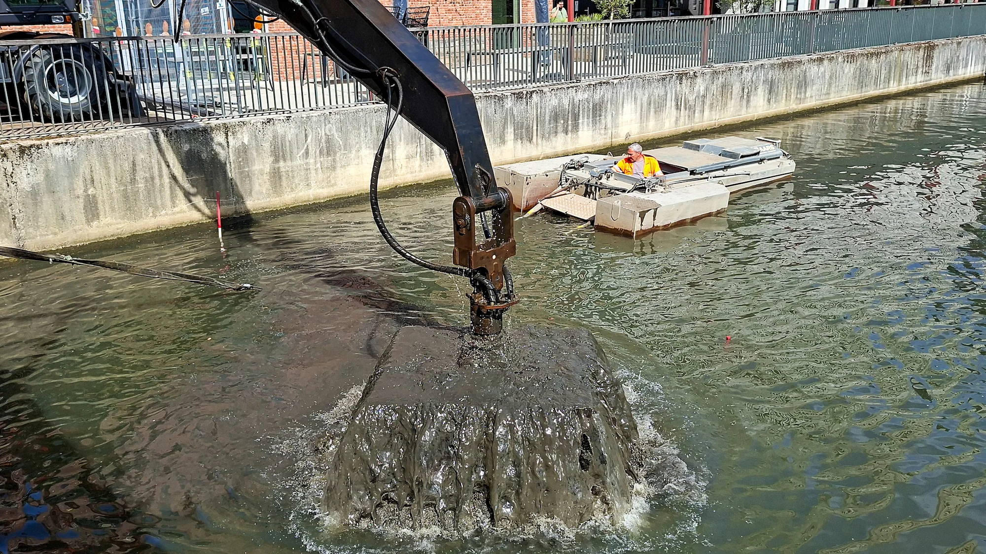 Close up van baggerbak die slib uit watergang verwijdert tijdens baggerwerkzaamheden