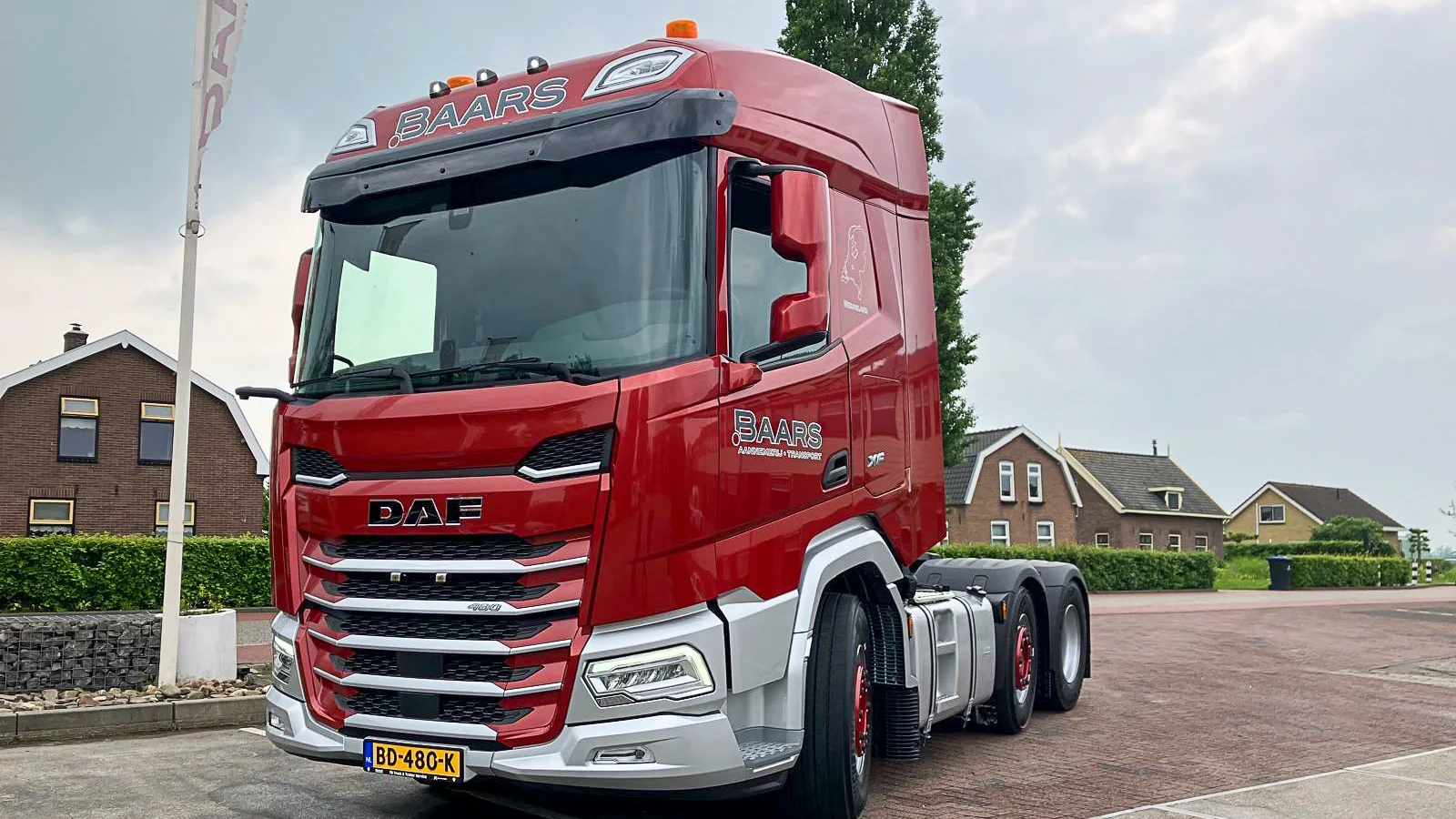 Nieuwe rode DAF vrachtwagen van Baars Transport klaar voor inzet op zonnige locatie