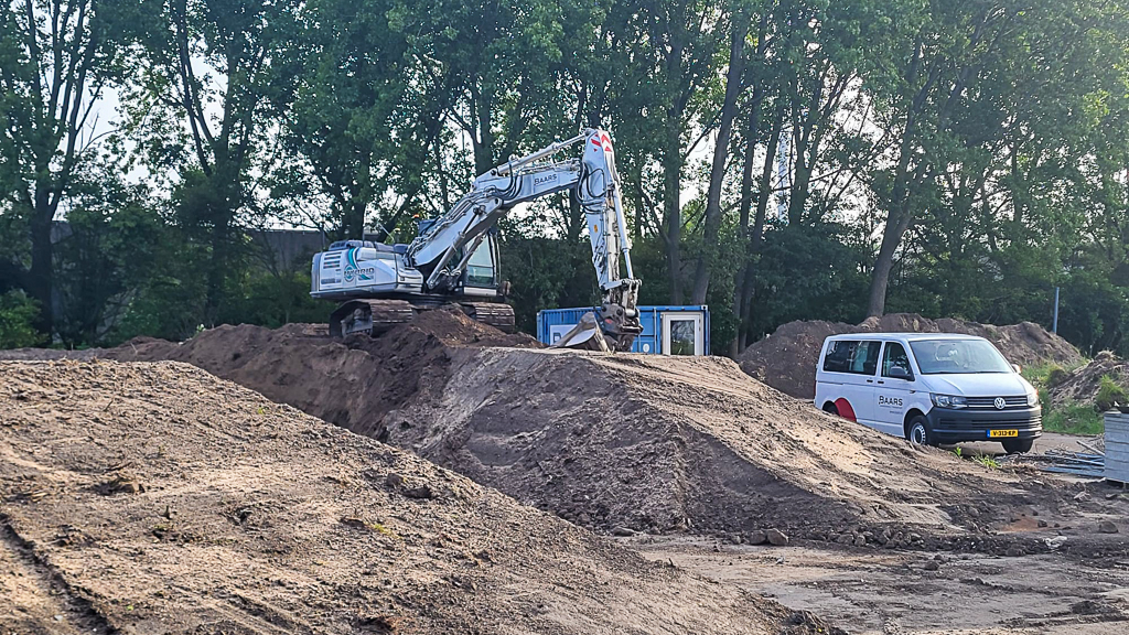 Rupskraan in actie op het depotterrein tijdens het profileren en verplaatsen van grond. De werkzaamheden vormen de basis voor de verdere inrichting van het baggerdepot.