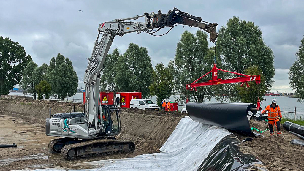 Met behulp van een hydraulische graafmachine wordt het foliemateriaal nauwkeurig uitgerold en aangebracht in de depotvakken van De Groote Lucht.