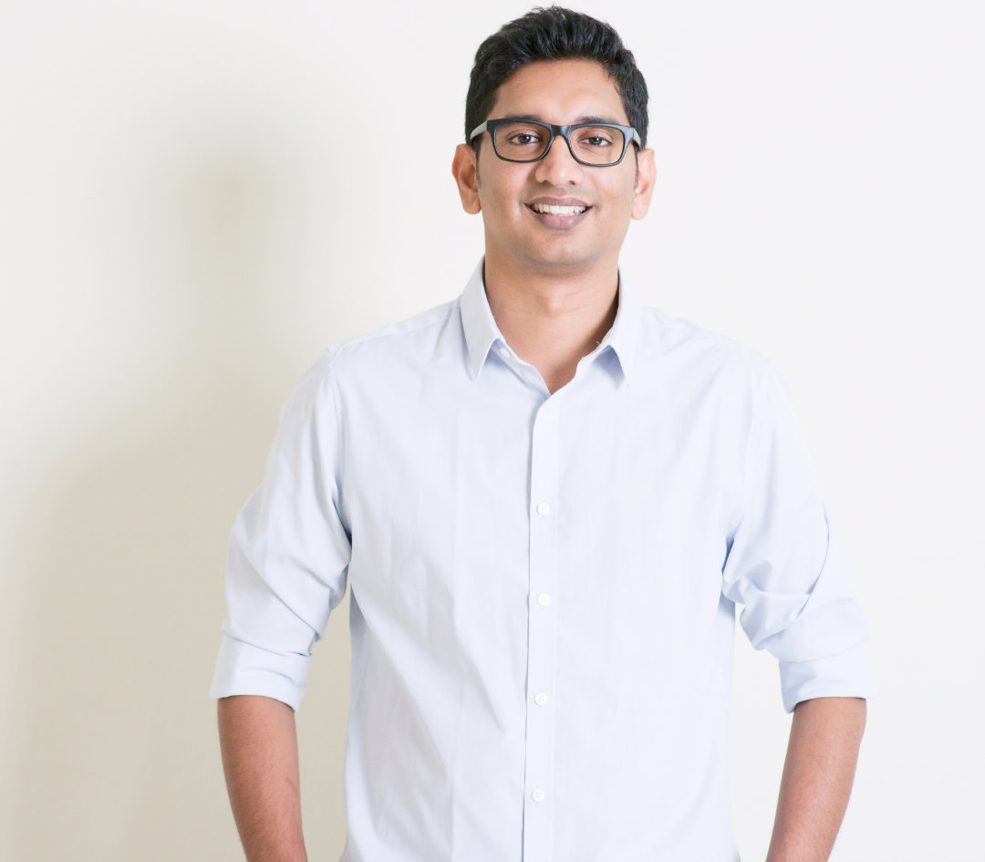 Confident woman in white shirt holding laptop.