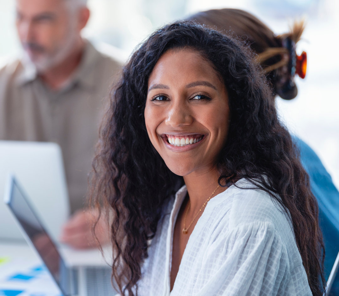 Confident woman with blonde hair, folded arms, and smiling.