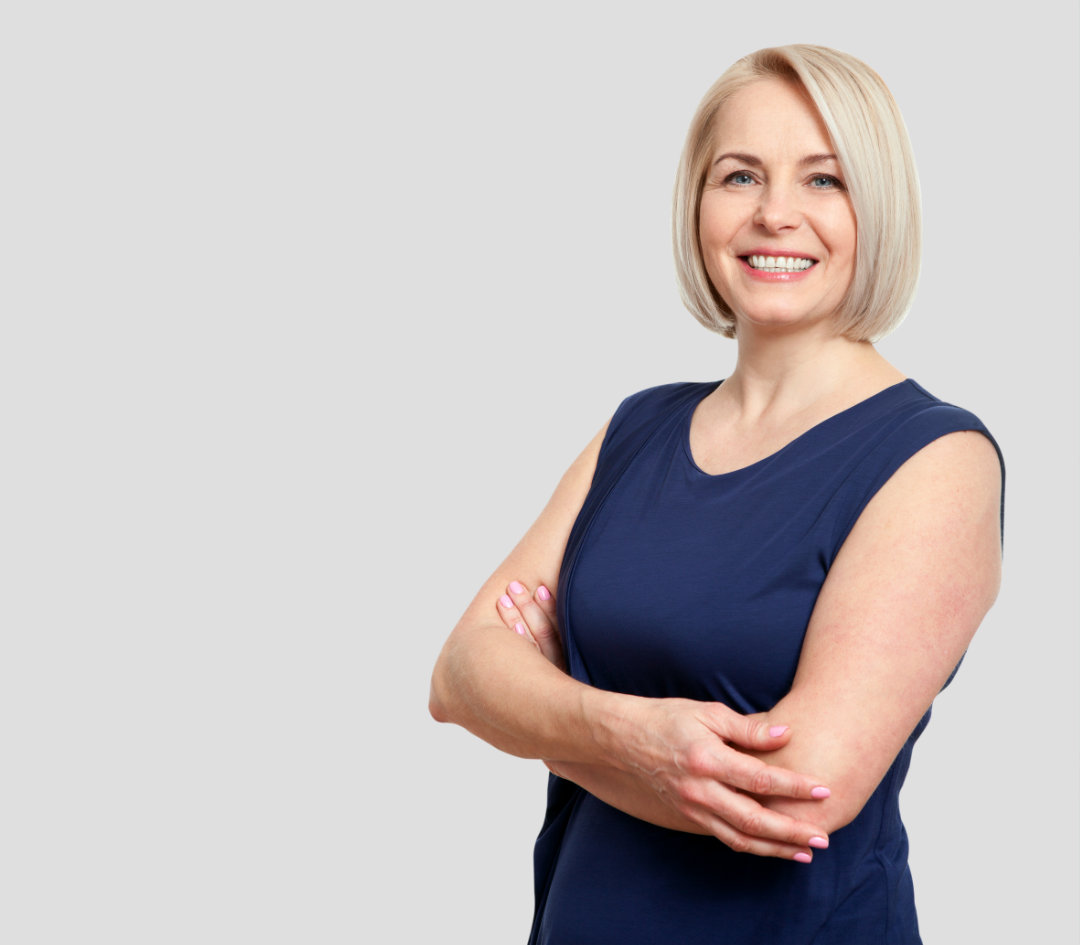 Confident woman with blonde hair, folded arms, and smiling.