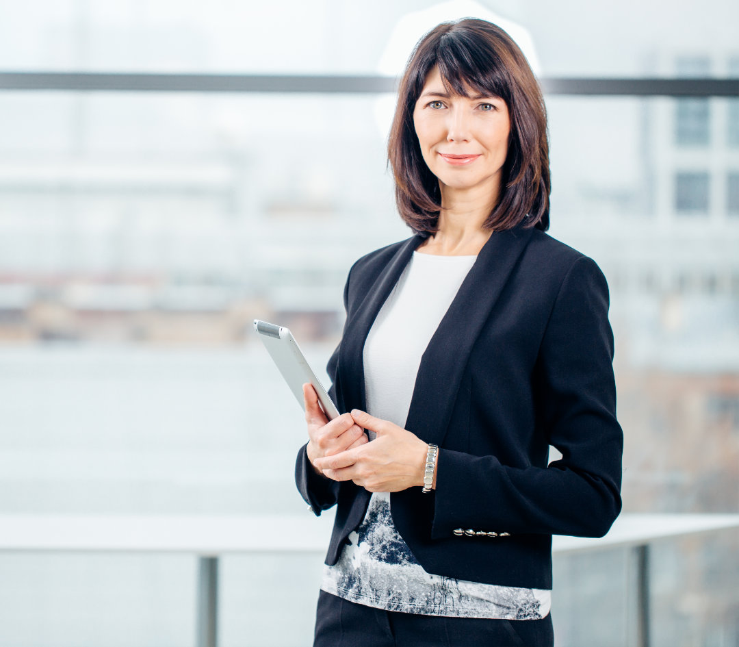 Woman in business attired reaching across table and confidently shaking a mans hand.