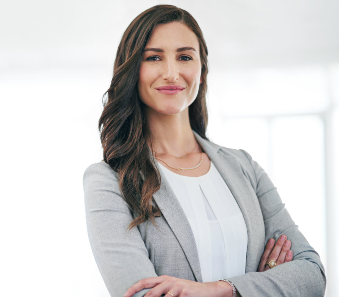 Woman in business attired reaching across table and confidently shaking a mans hand.