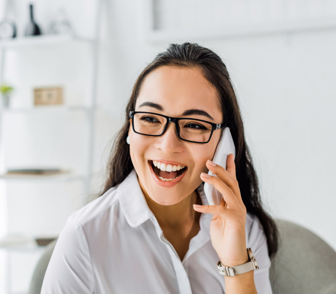 Confident woman in white shirt holding laptop.