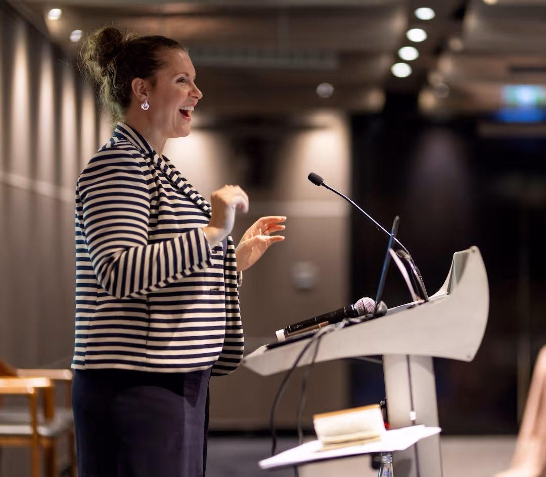 Confident woman with blonde hair, folded arms, and smiling.