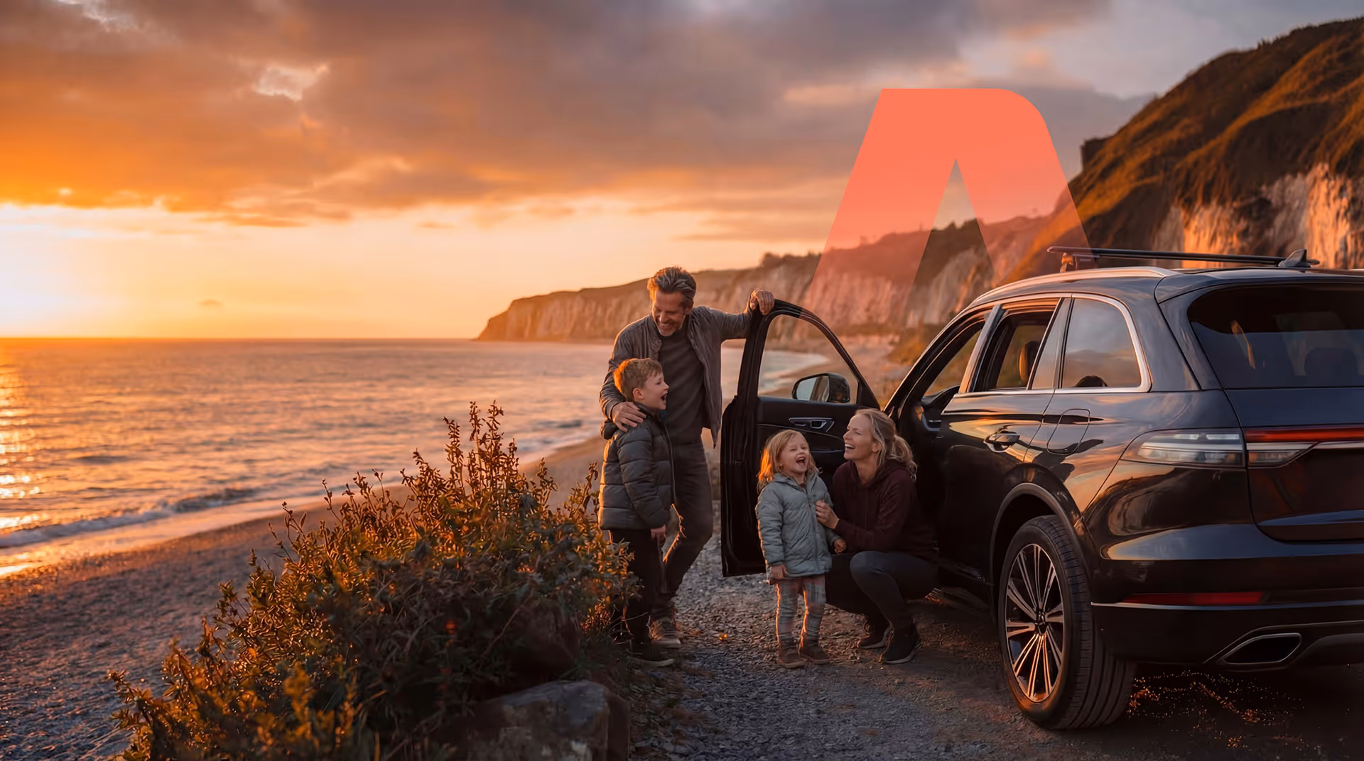 Family with two children smiling beside a black SUV parked near a beach at sunset.