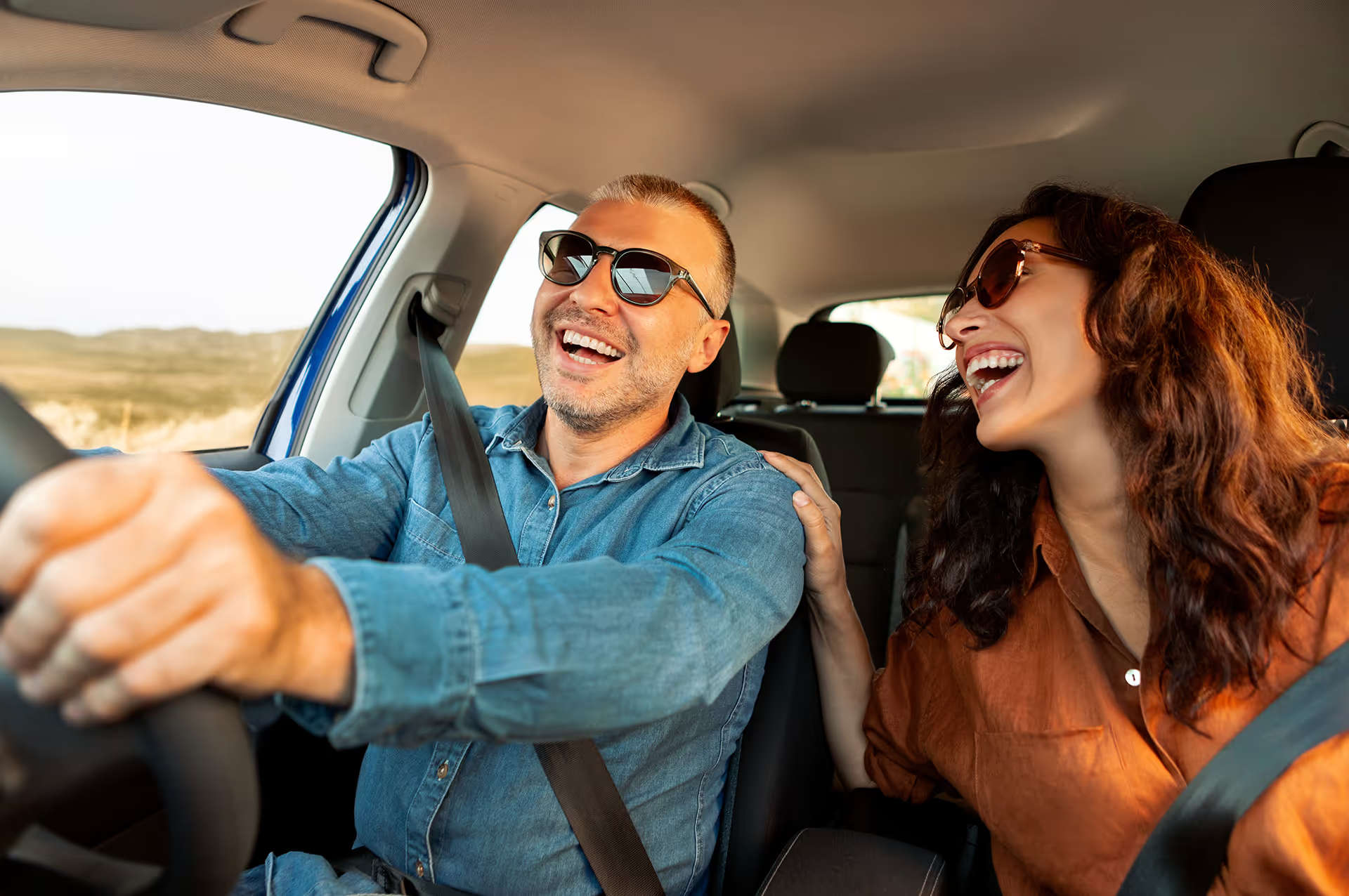 A smiling couple enjoying their new car