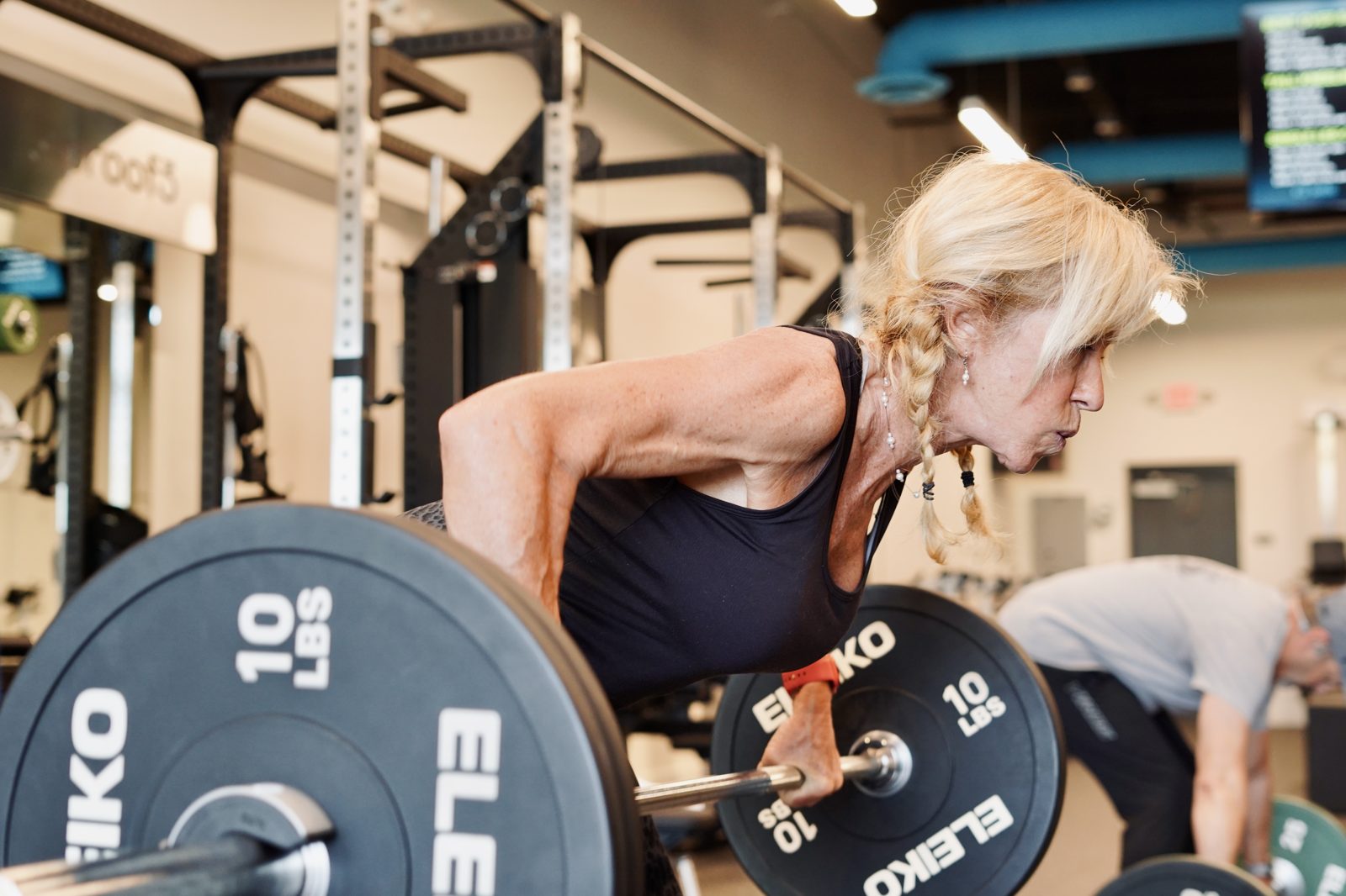 A member performs a barbell row in the proof3 studio.