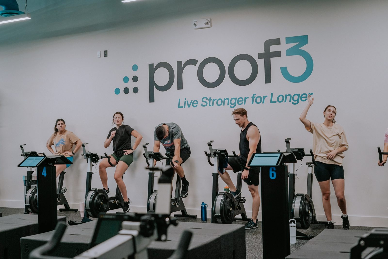 Members work through a small-group session in front of the proof3 wall.