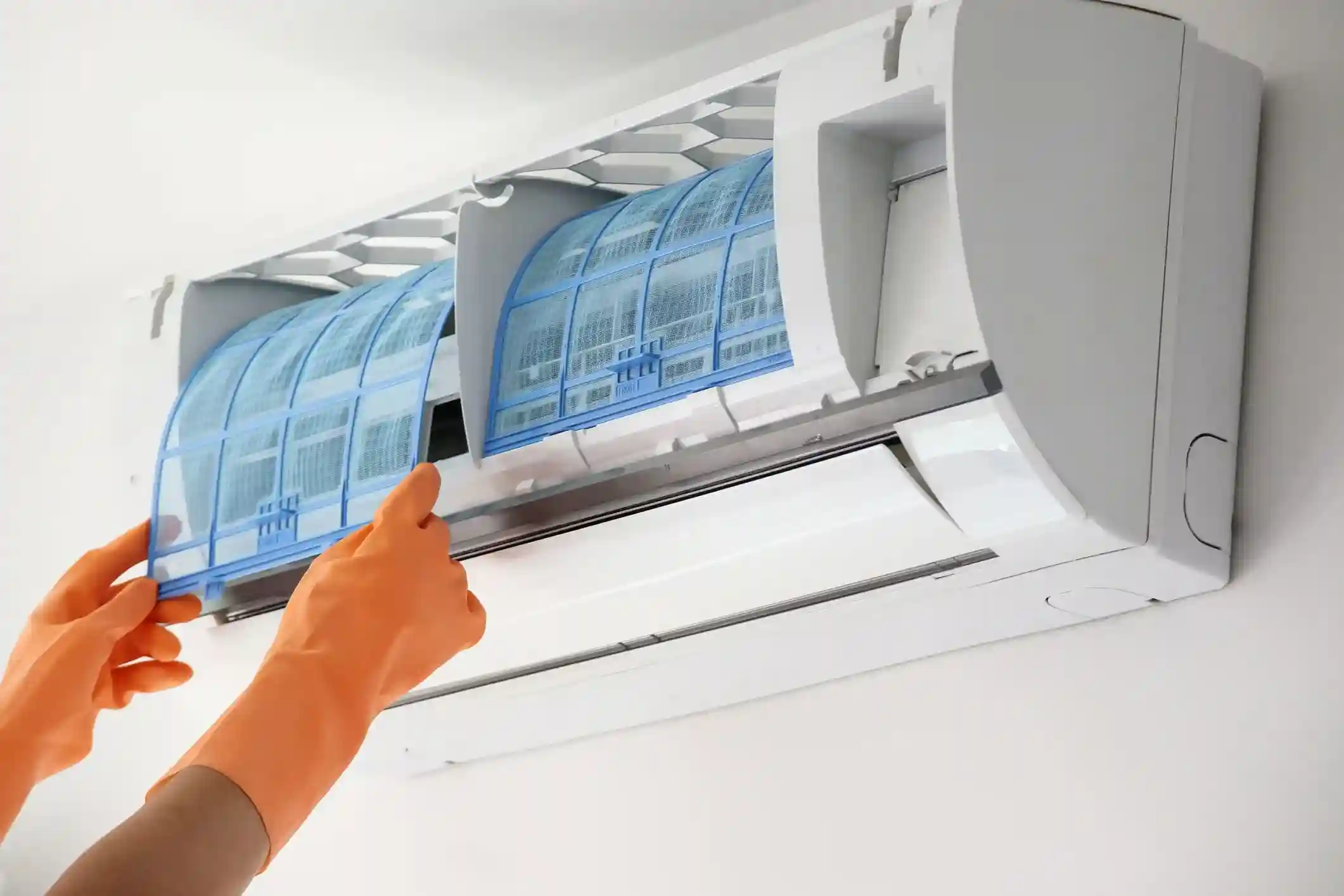 A close shot of repairing an Ductless AC unit by a hand with ge gloves