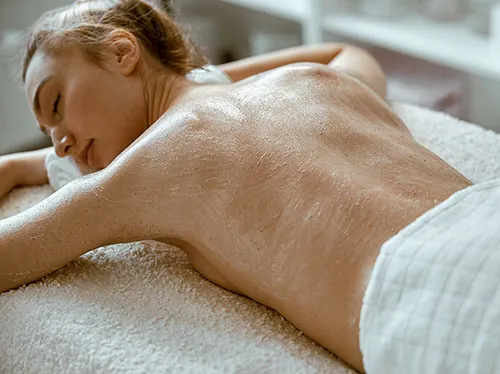 a woman receiving back facial treatment