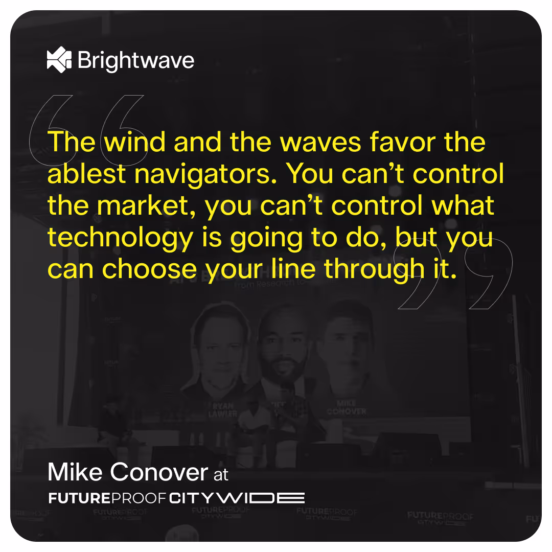 A digital graphic features a quote in bold yellow text on a dark, semi-transparent background. The quote reads: "The wind and the waves favor the ablest navigators. You can’t control the market, you can’t control what technology is going to do, but you can choose your line through it." Below the quote, in white text, it attributes the statement to Mike Conover at FUTUREPROOF CITYWIDE. The background shows a blurred image of a panel discussion with three speakers’ faces displayed on a large screen. The image includes the Brightwave logo in the upper left corner.