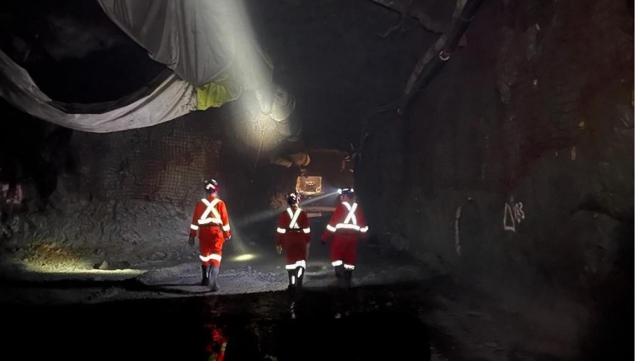 A group of men in red uniforms walking in a dark tunnelAI-generated content may be incorrect.