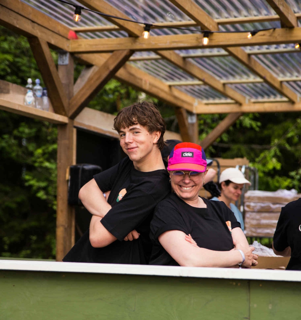 Tre frivillige som holder rundt hverandre og smiler