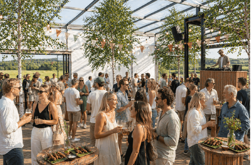 En gruppe mennesker som sitter i storsalen og smiler mot kamera