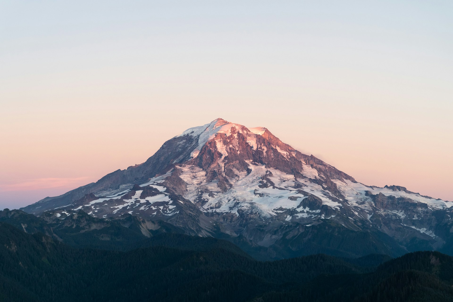 Mt. Rainier (also known as Tahoma or Tacoma) softly glows blue and red on the evening of September 6th, 2020. This is the northwestern slope seen from the window of a Cessna 172 light aircraft. In the late summer the mountain's ice and snow is at a season low.