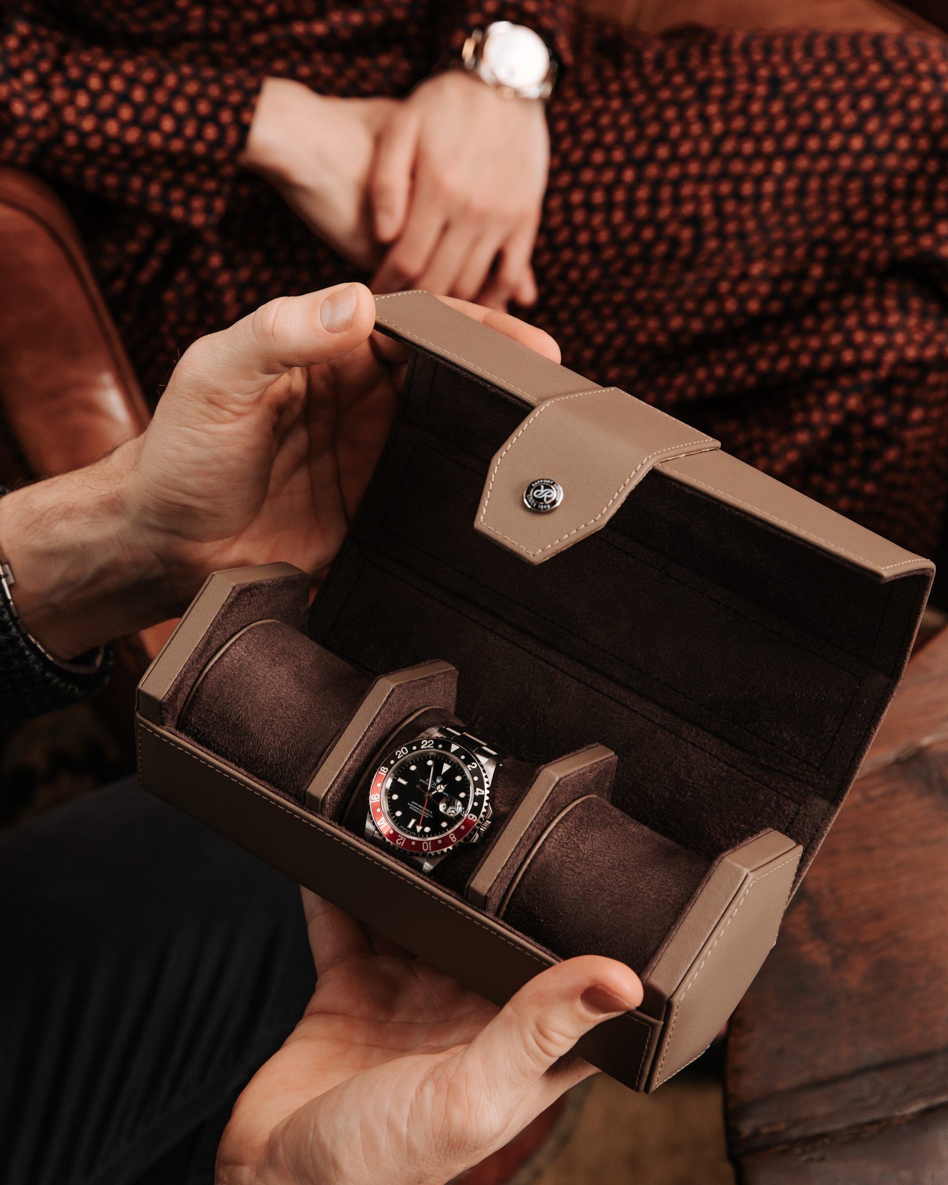 Man placing a watch into a Rapport London leather watch roll, shot by 303 London