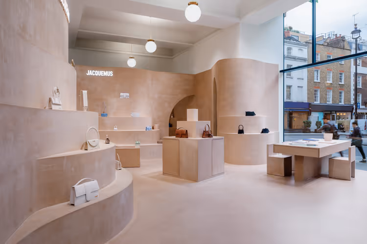 Minimalist Jacquemus store interior with beige clay walls, evoking the atmosphere of Provence. Simple, playful design showcases the brand's signature style and connection to its Southern French roots.
