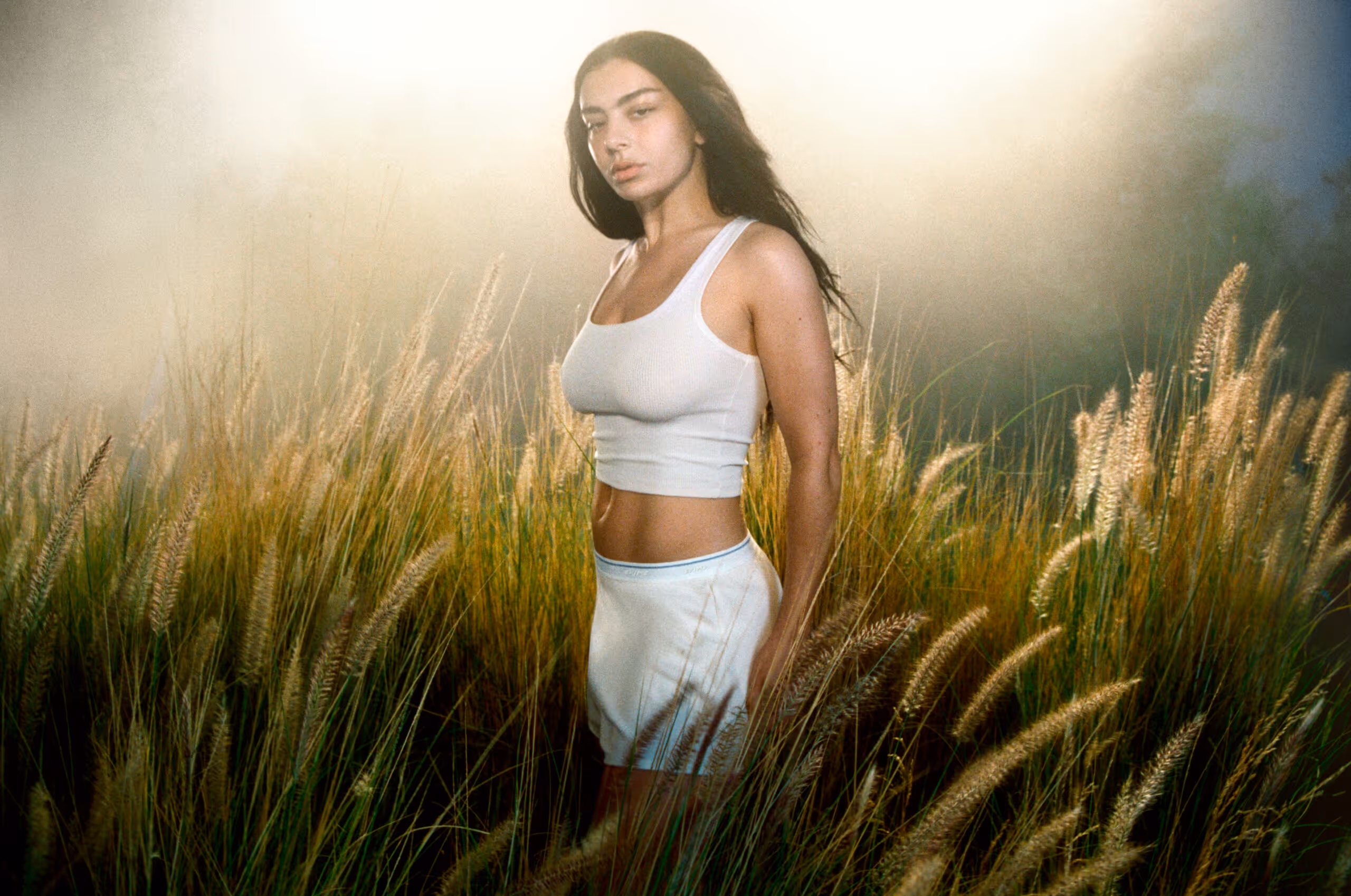 In a vibrant photoshoot, Charli XCX wears SKIMS pieces, highlighting her bold fashion sense and modern aesthetics