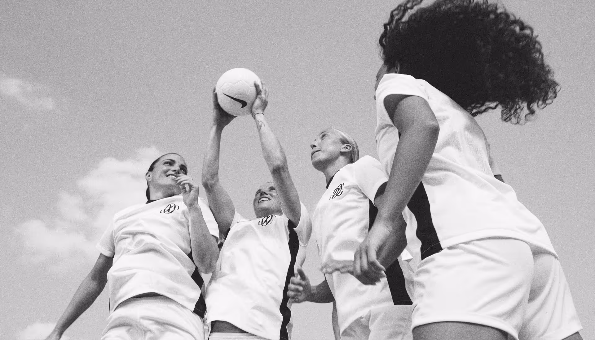 FC Como Women players celebrate on the pitch, wearing their new Nike kits, symbolizing the start of a new era for the team.