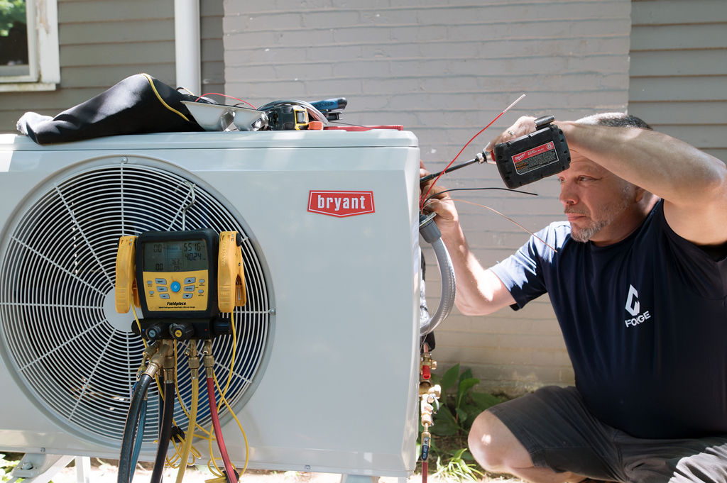 Forge HVAC tech servicing an outdoor condenser