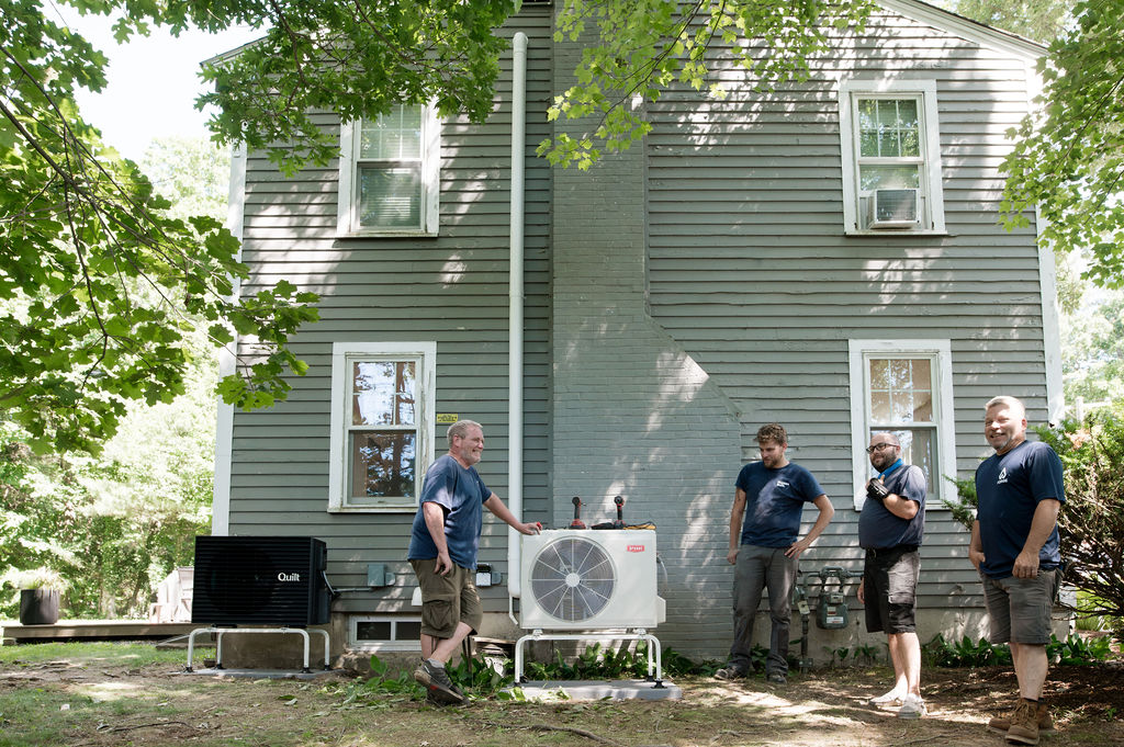 Forge HVAC technician hanging up a mini-split for a heat pump installation 