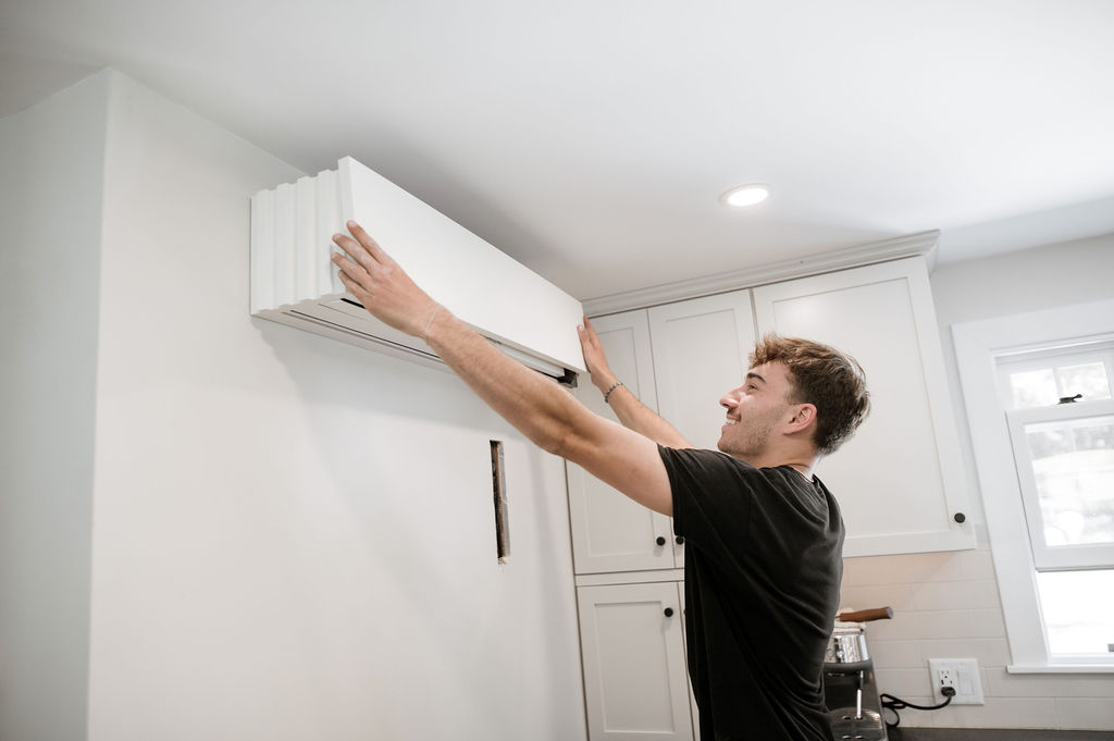 A Forge installer pressing an indoor mini split head onto its wall bracket