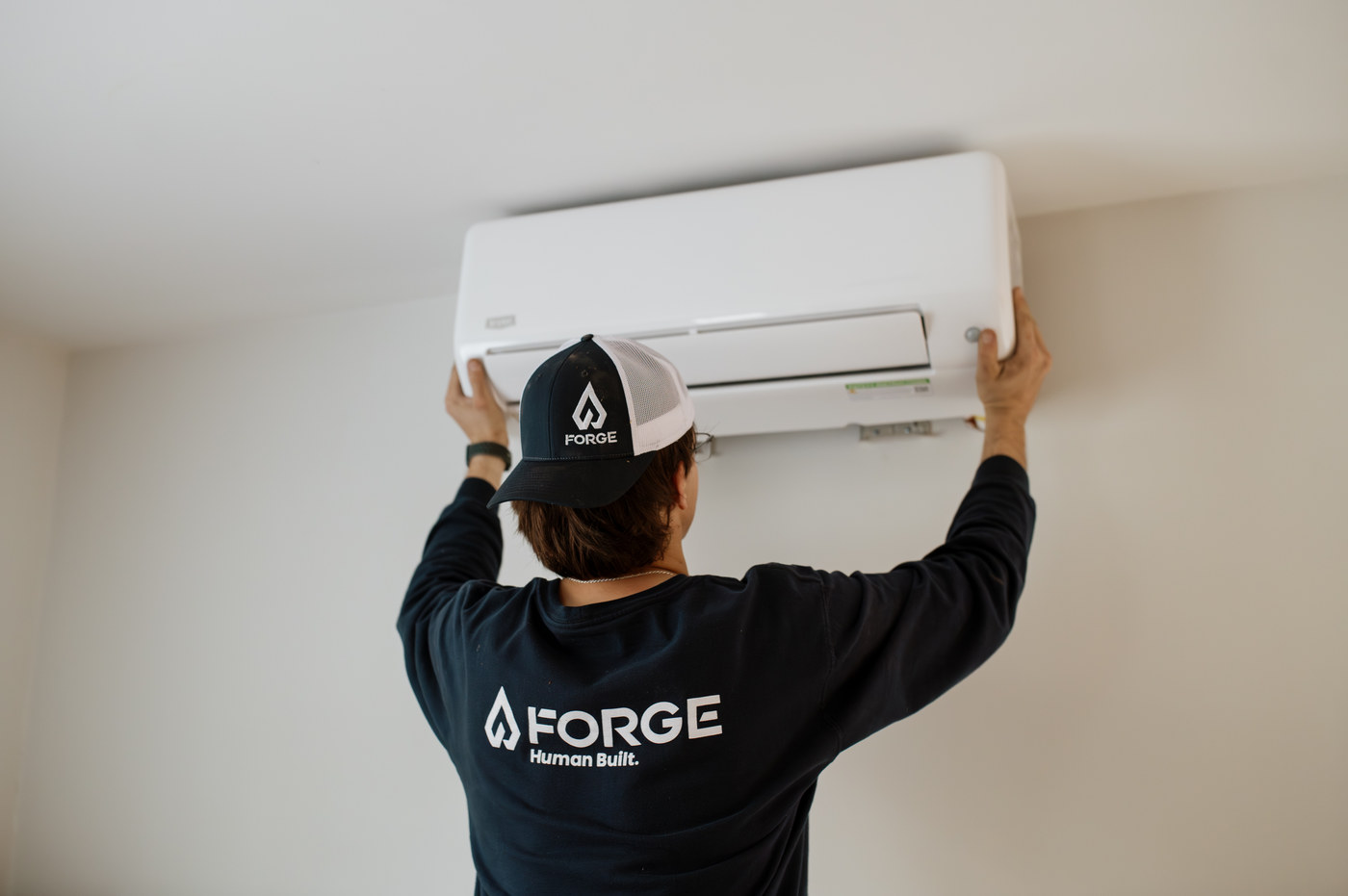 A Forge installer mounting an indoor wall unit