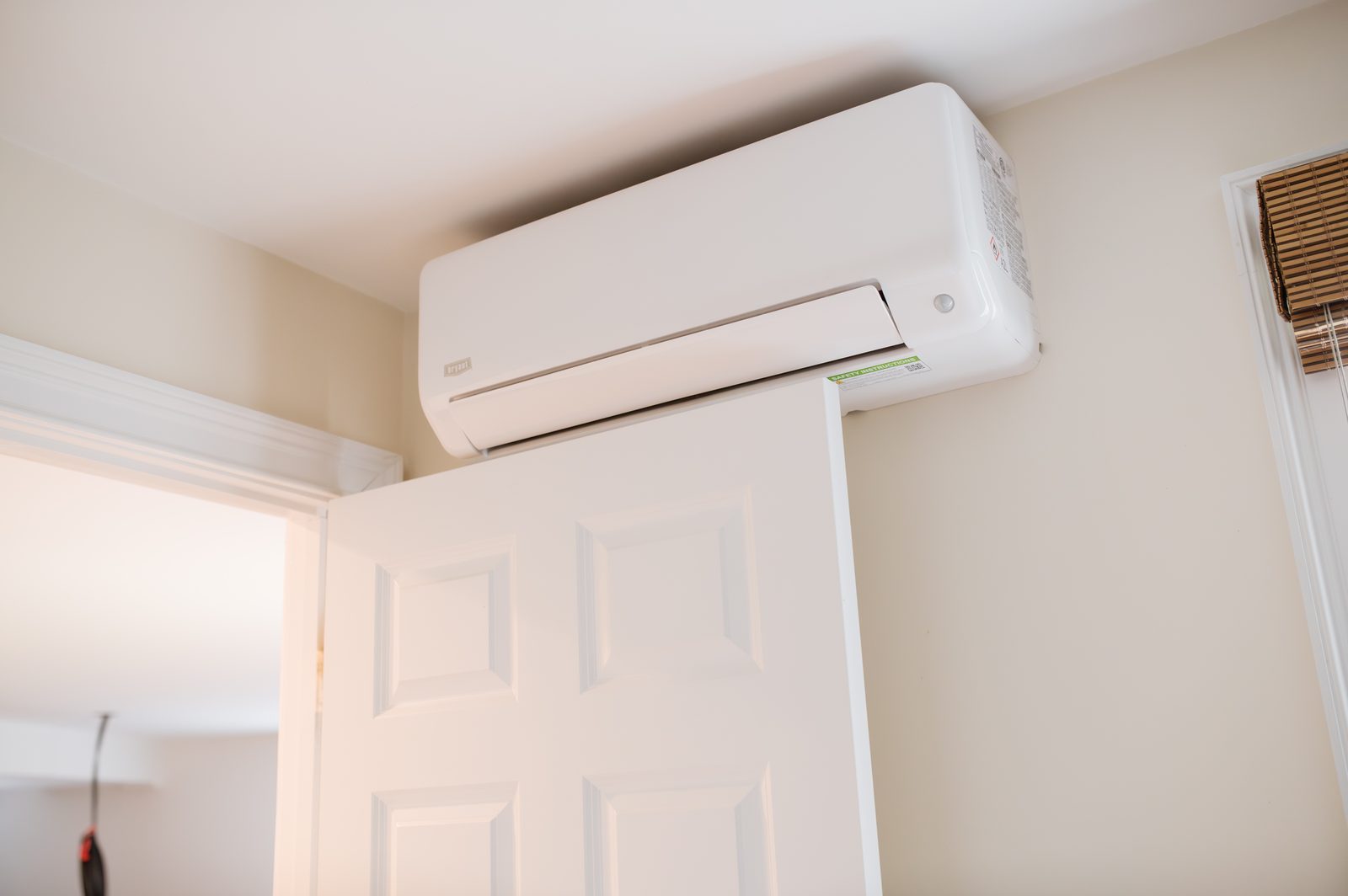 A finished mini split head mounted above a doorway