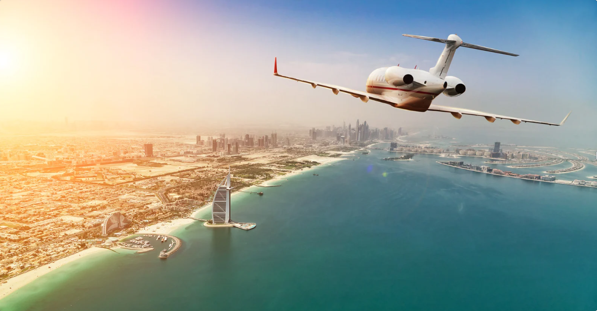 Private jet plane flying above Dubai city in beautiful sunset light
