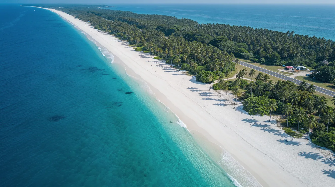 An aerial view showcases a stunning tropical coastline with crystal-clear turquoise waters and a pristine white sand beach, complemented by a small runway nestled among palm trees, ideal for private jet travel and exclusive getaways. This picturesque scene evokes thoughts of luxury private jet charter services, perfect for a memorable birthday celebration or surprise getaway.