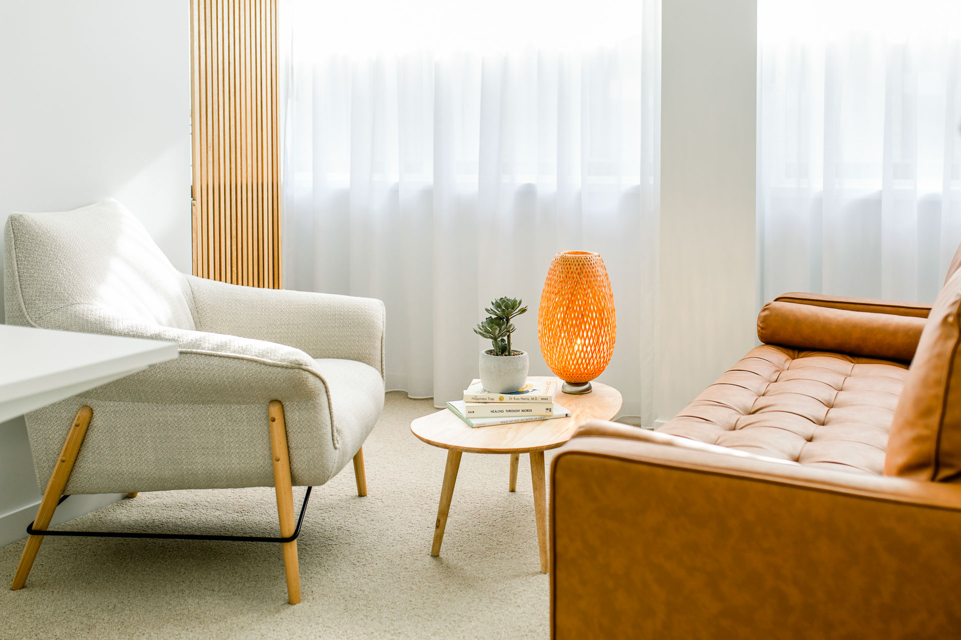 A stylish room displaying a couch, chair, table, and lamp, perfect for great conversations.