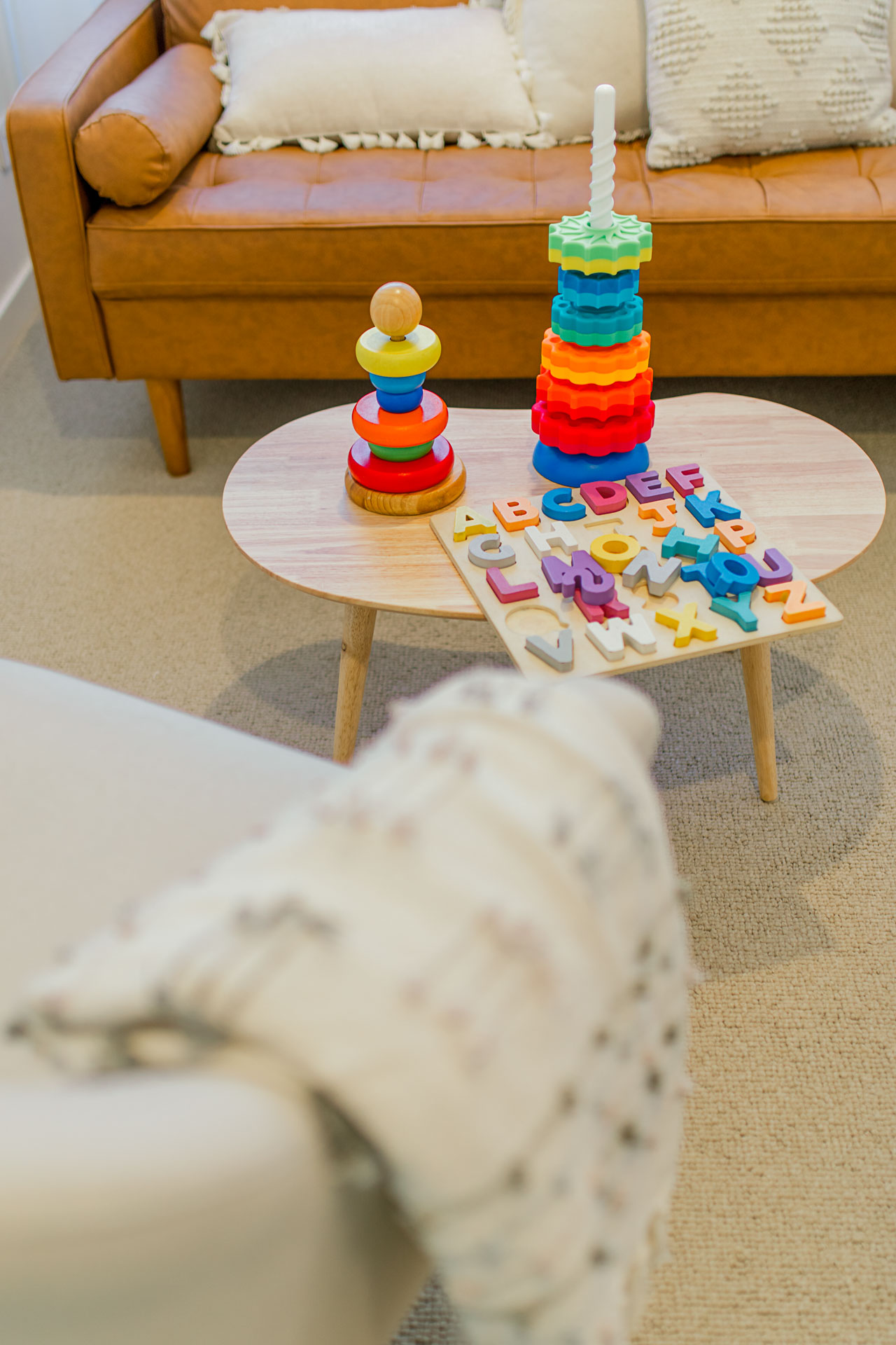 A cozy room featuring a couch, and a small table with a collection of learning materials, creating a welcoming vibe.
