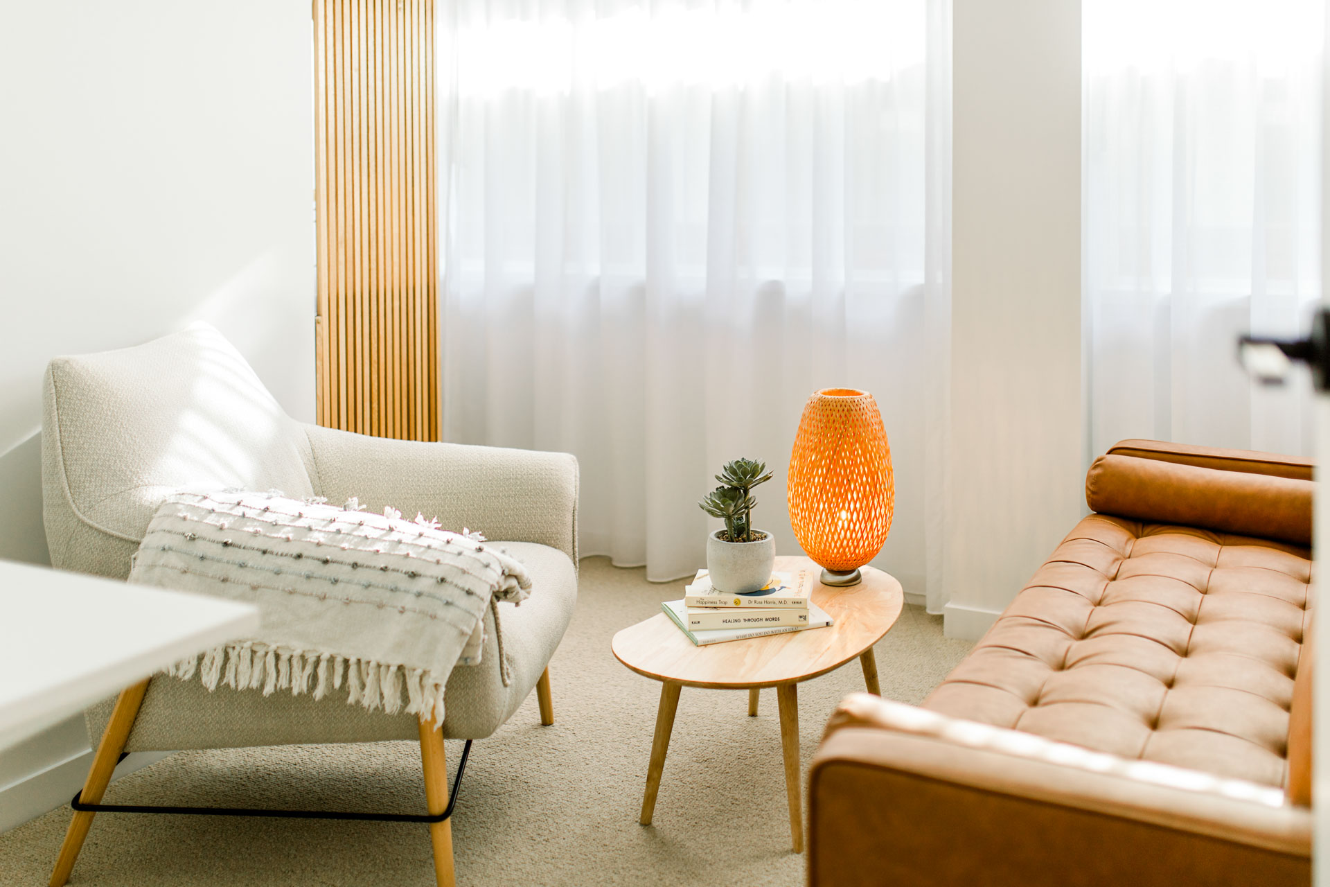 A stylish room displaying a couch, chair, table, and lamp, perfect for nice conversations.