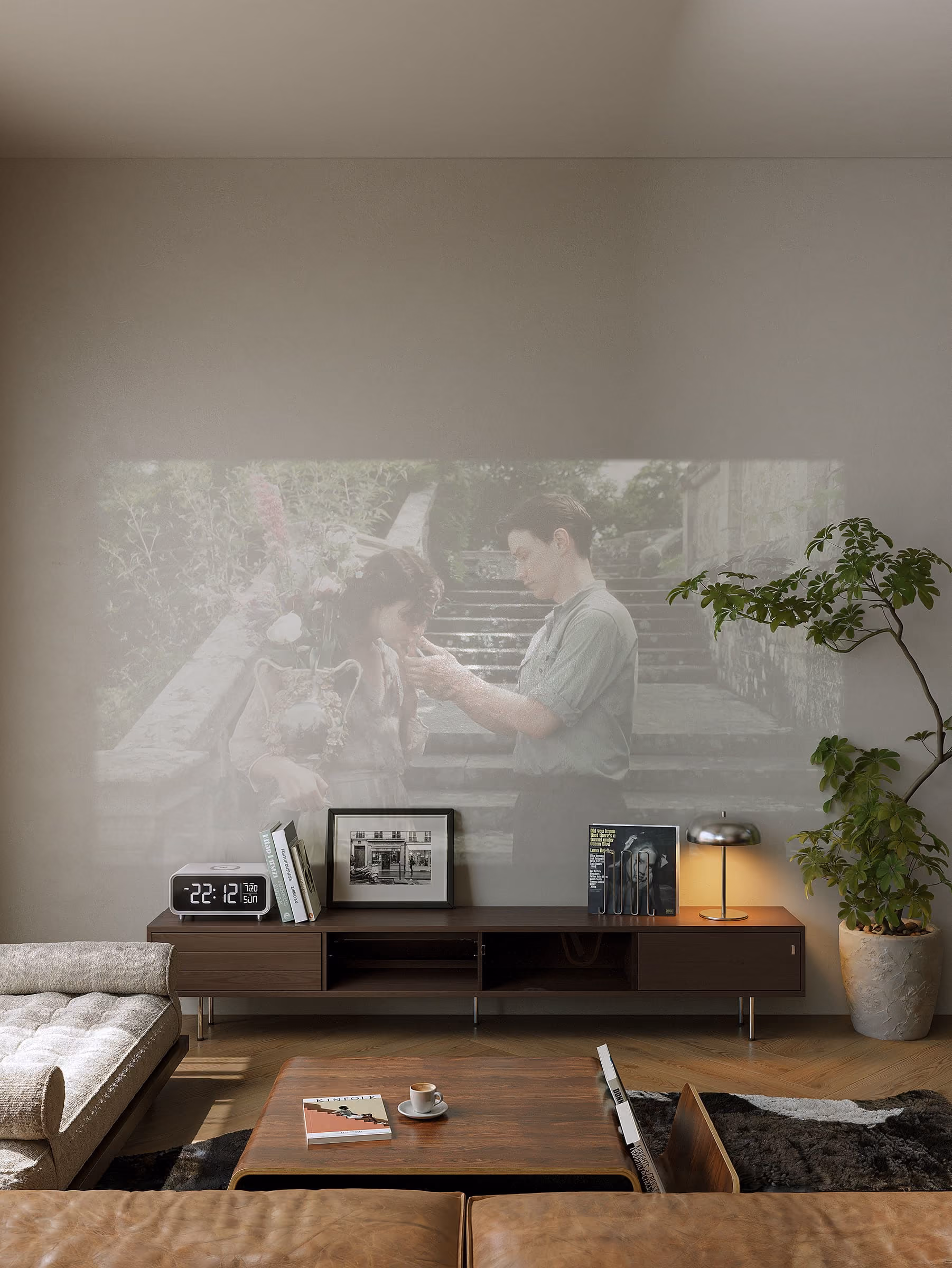 *Fragment is a modern four-story apartment building with balconies featuring green plants, a car parked in driveway, and a blurred white car driving on the street in front.
