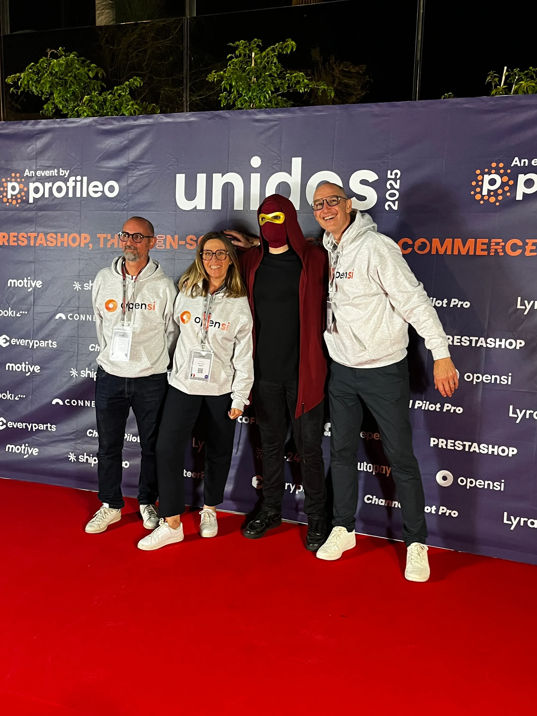 Quatre personnes souriantes sur un tapis rouge devant une bannière de l'événement Profileo Unidos 2025.