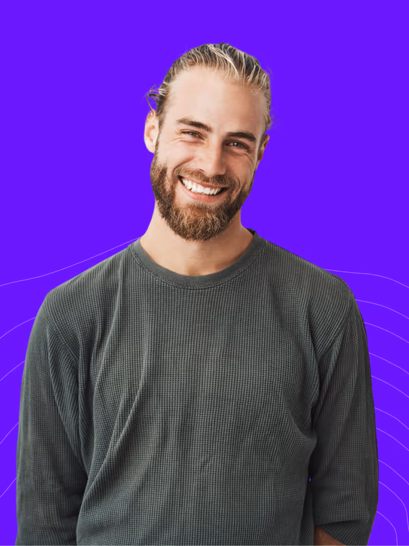 a happy, smiling team member with a beard on a light purple background